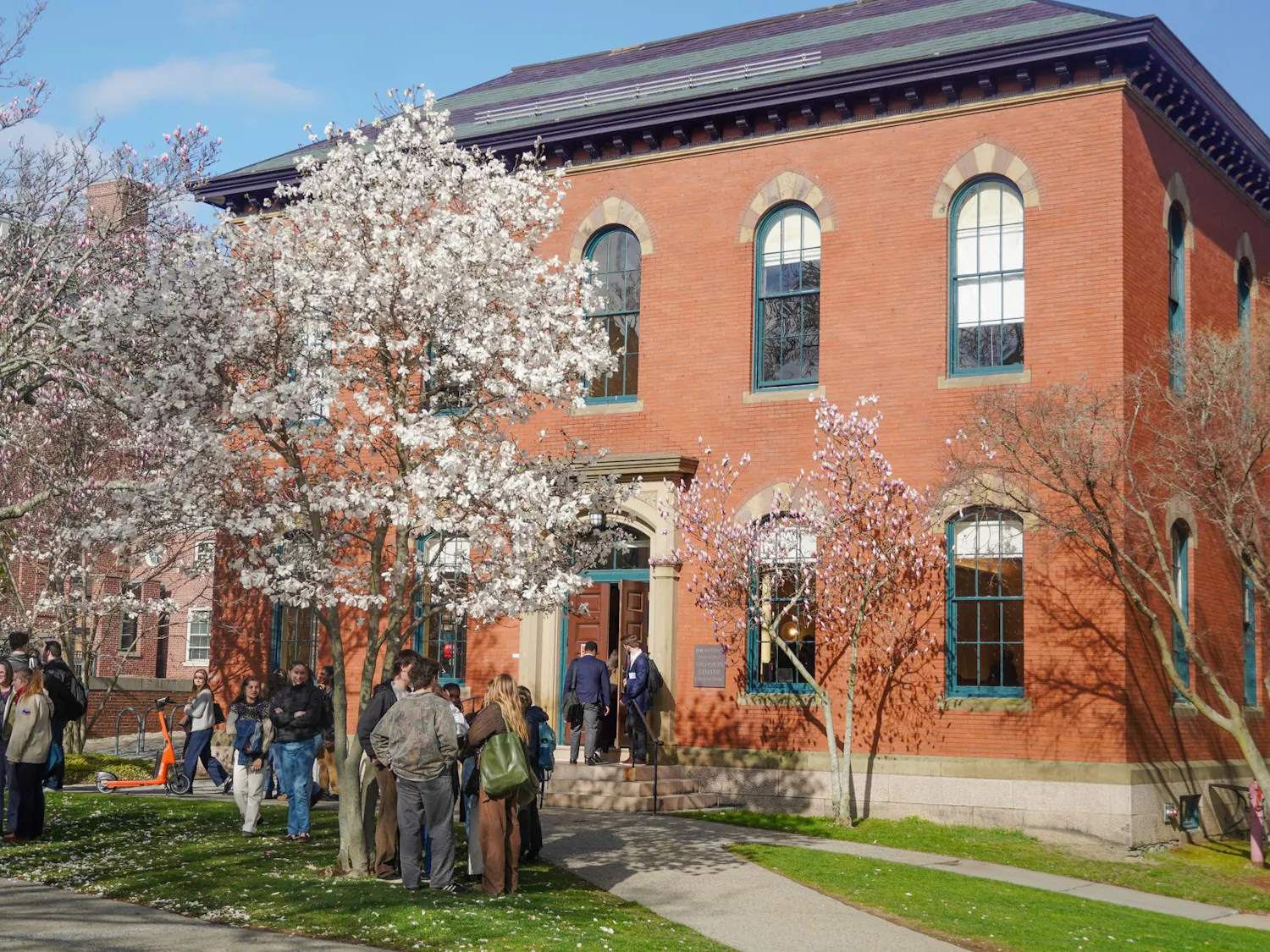 A picture of Salomon Hall on ADOCH. The picture shows prospective students standing outside the Main Green entrance to the building surrounded by flowering trees.
