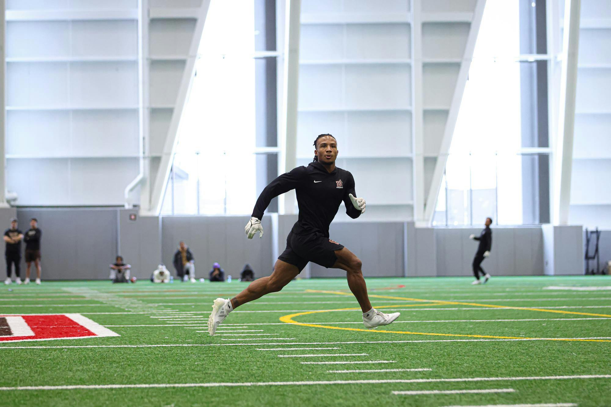 A man runs across a turf field. 