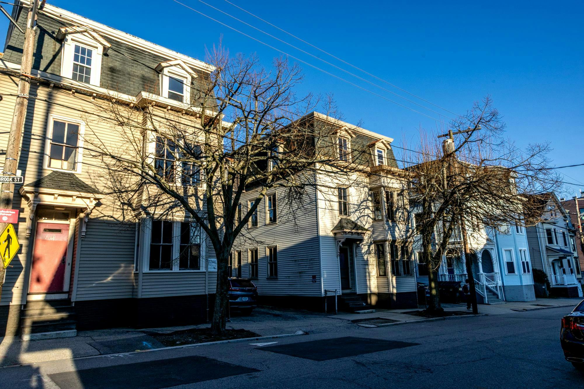 A photo of houses on Brook Street during the day. There are trees in front of the houses.