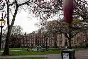 Photo of Brown’s campus with a large brick building in the center and green lawn in front.

