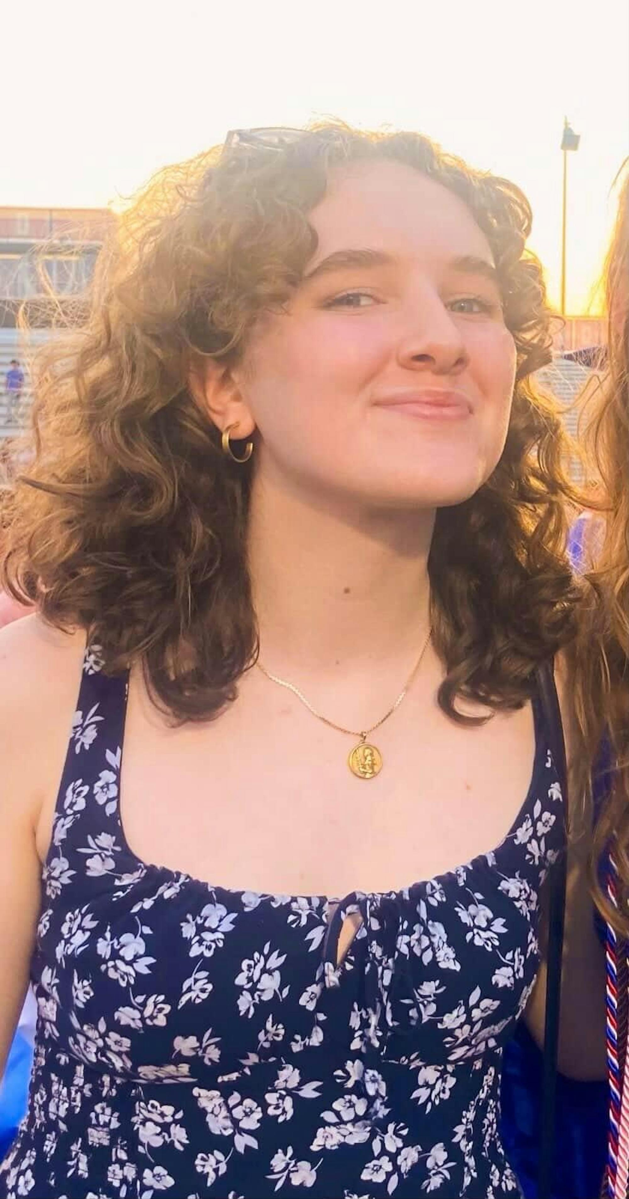 A photo of a girl with curly brown hair.