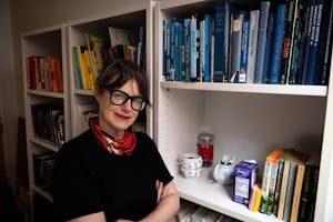 A photo of Sibyl Kempson, the new head of MFA playwriting, next to a bookshelf.
