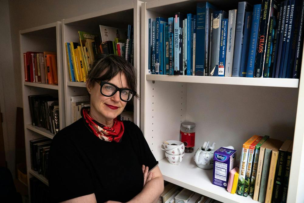A photo of Sibyl Kempson, the new head of MFA playwriting, next to a bookshelf.