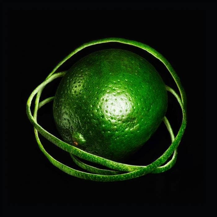 The album cover, which depicts a green lime with rings of lime peels around it. It stands out against a black background.