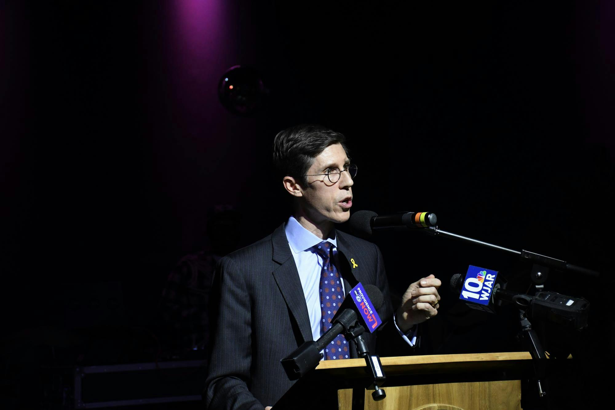 Mayor Brett Smiley speaking behind a wooden podium with microphones attached to it.