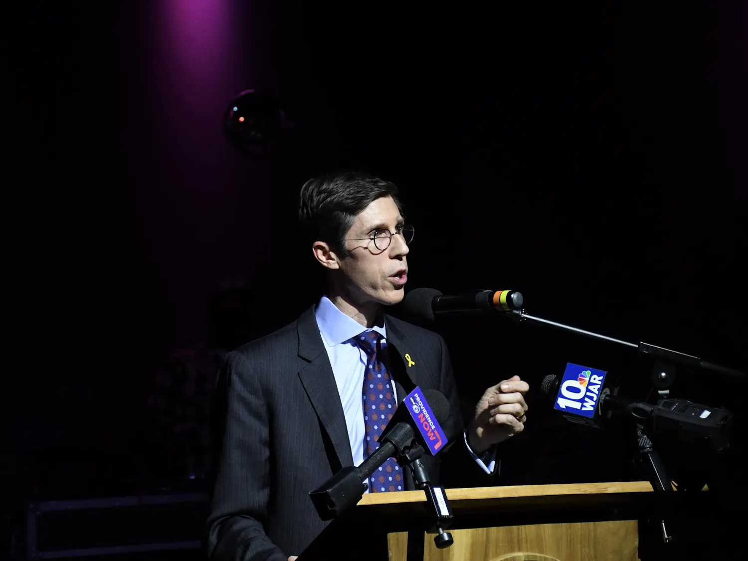 Mayor Brett Smiley speaking behind a wooden podium with microphones attached to it.