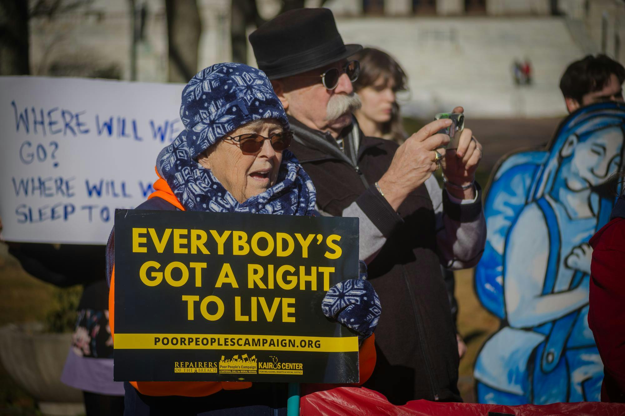 Rally in which a woman is holding a sign stating "Everybody's got a right to live"
