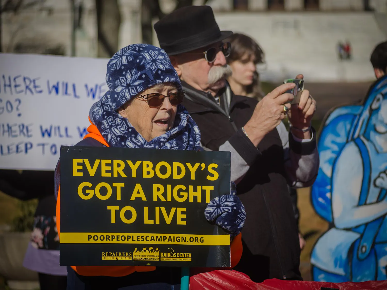 Rally in which a woman is holding a sign stating "Everybody's got a right to live"
