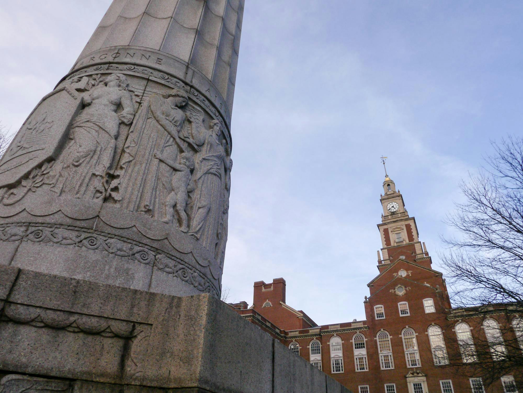 Photo showing an intricate grey concrete column and brick building. 