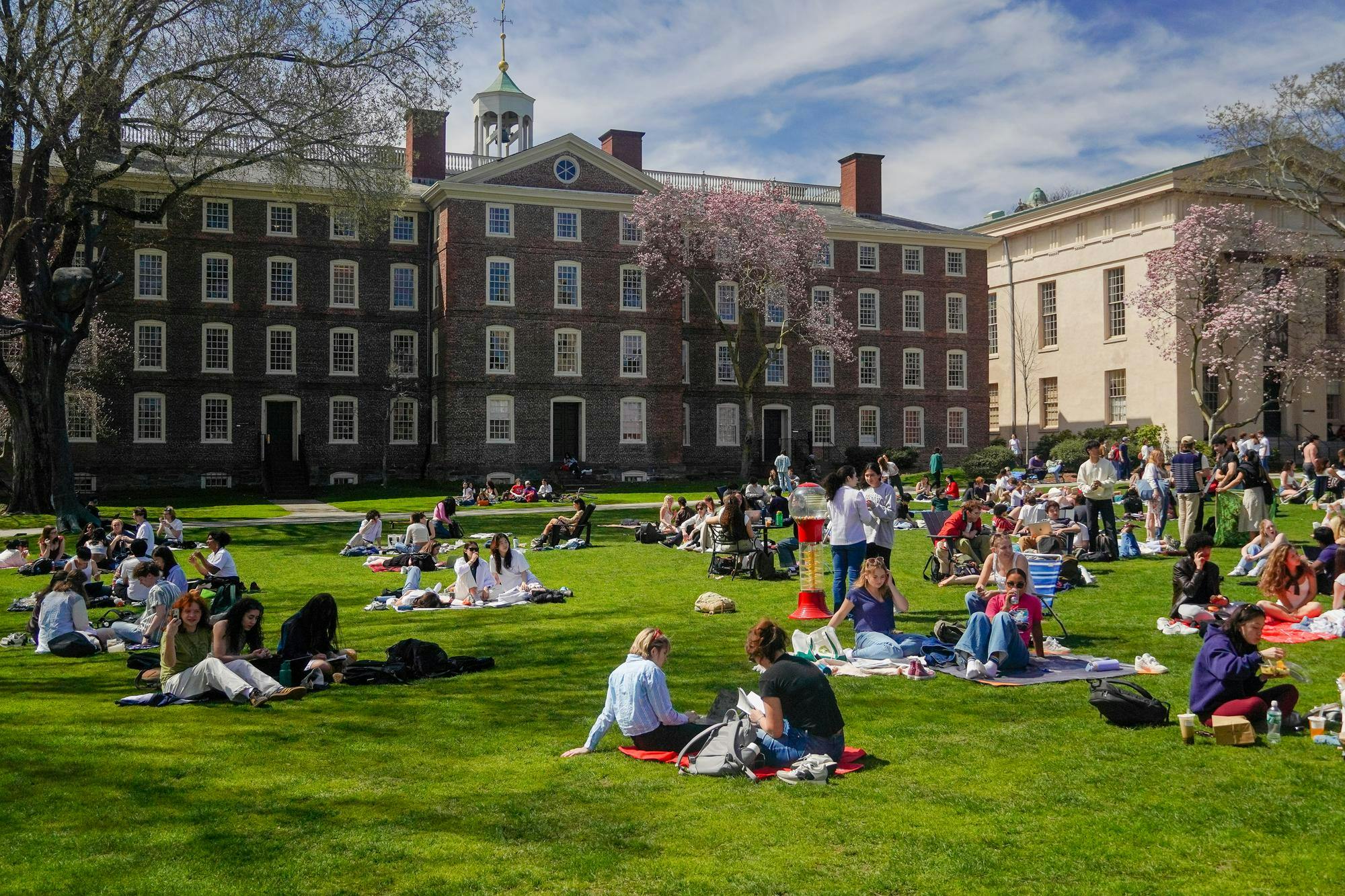 The Main Green on a sunny day with many students sitting on the grass