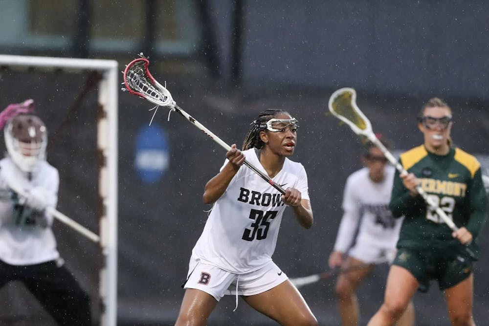 A photo of a women’s lacrosse player in the rain.