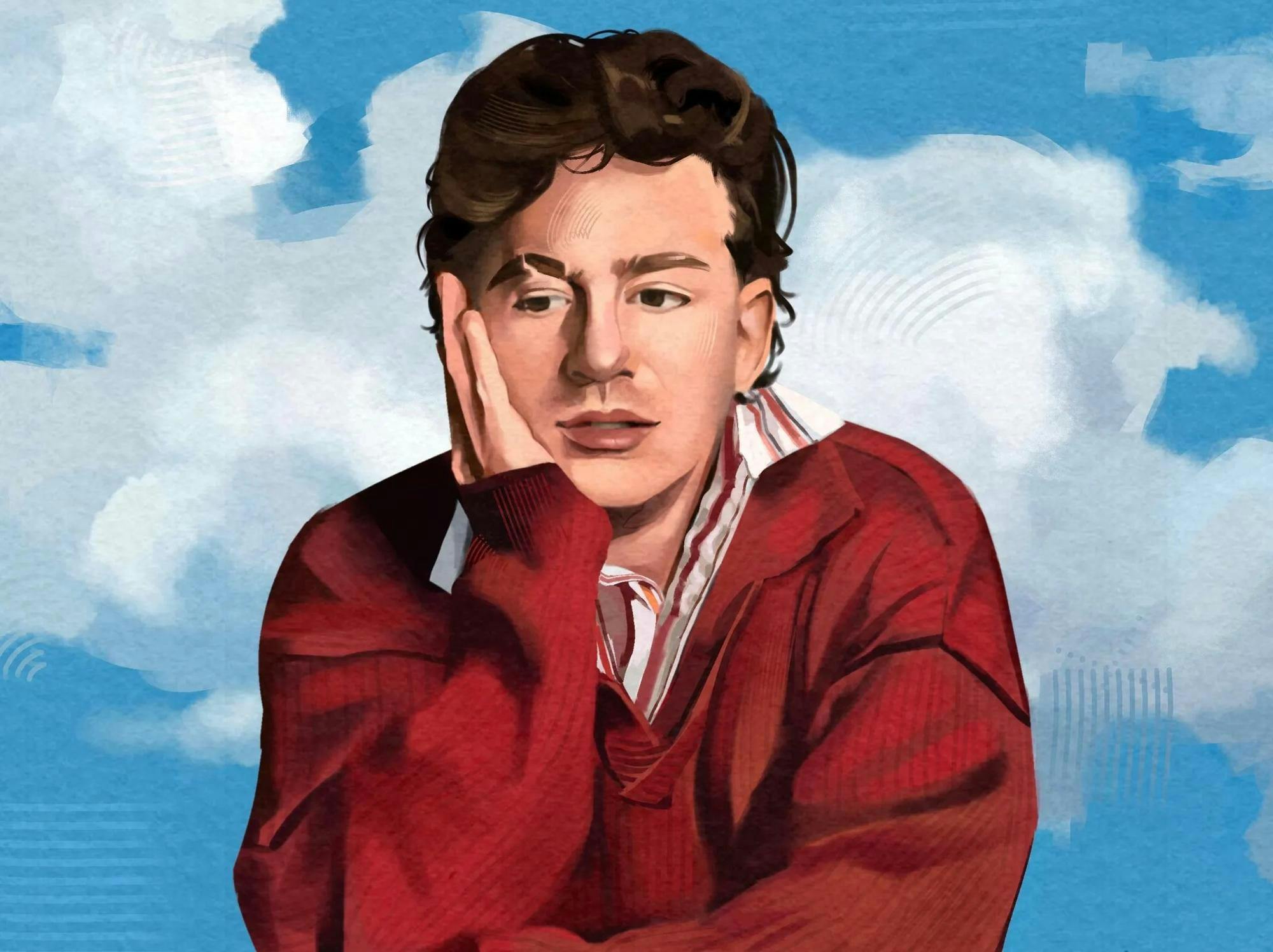 Charlie Puth, wearing a red shirt, leans with a hand on his cheek against a background of the sky. 