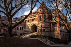 Photo with a golden hue of Lyman Hall, a large, old brick building.

