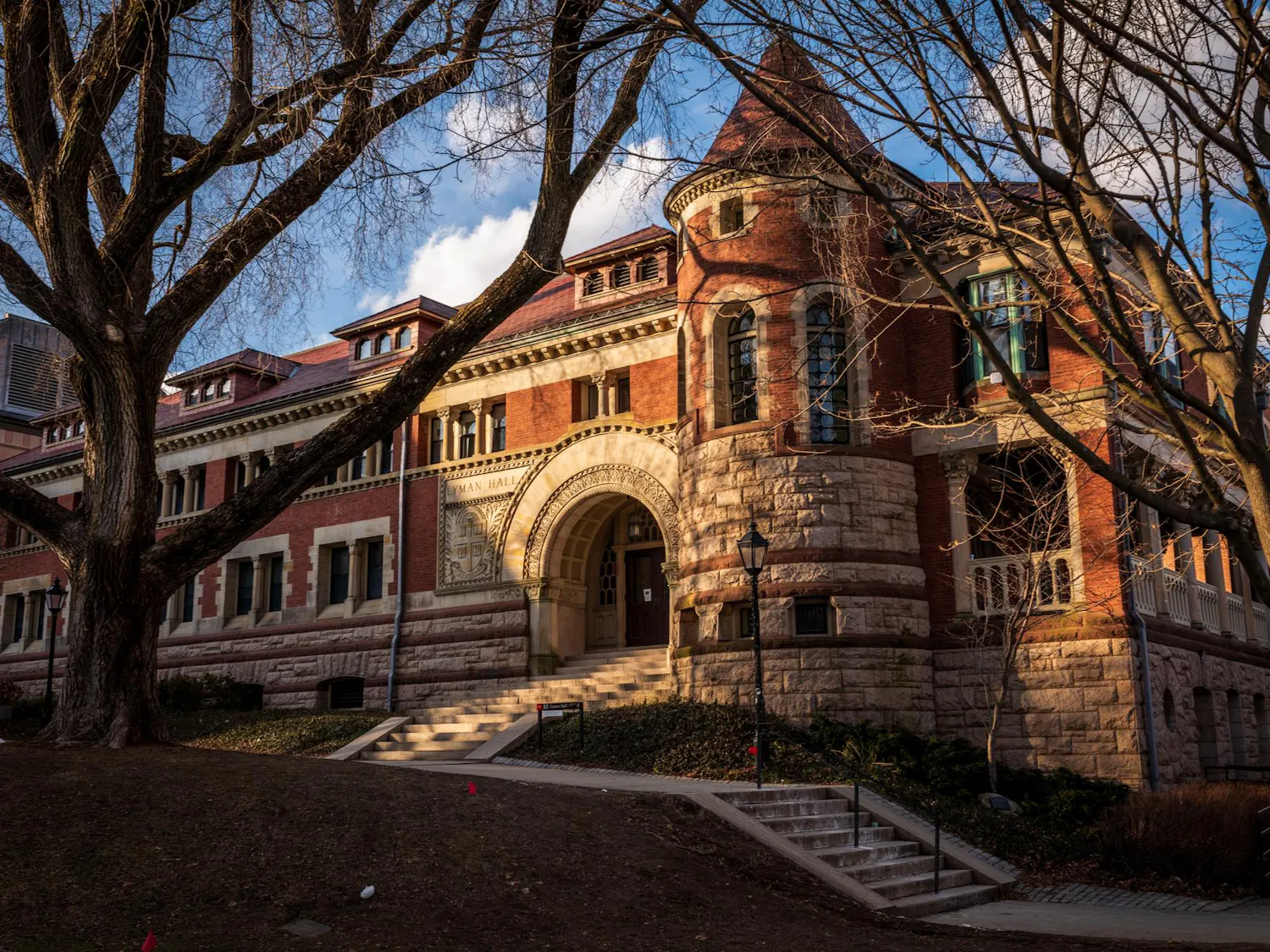 Photo with a golden hue of Lyman Hall, a large, old brick building.