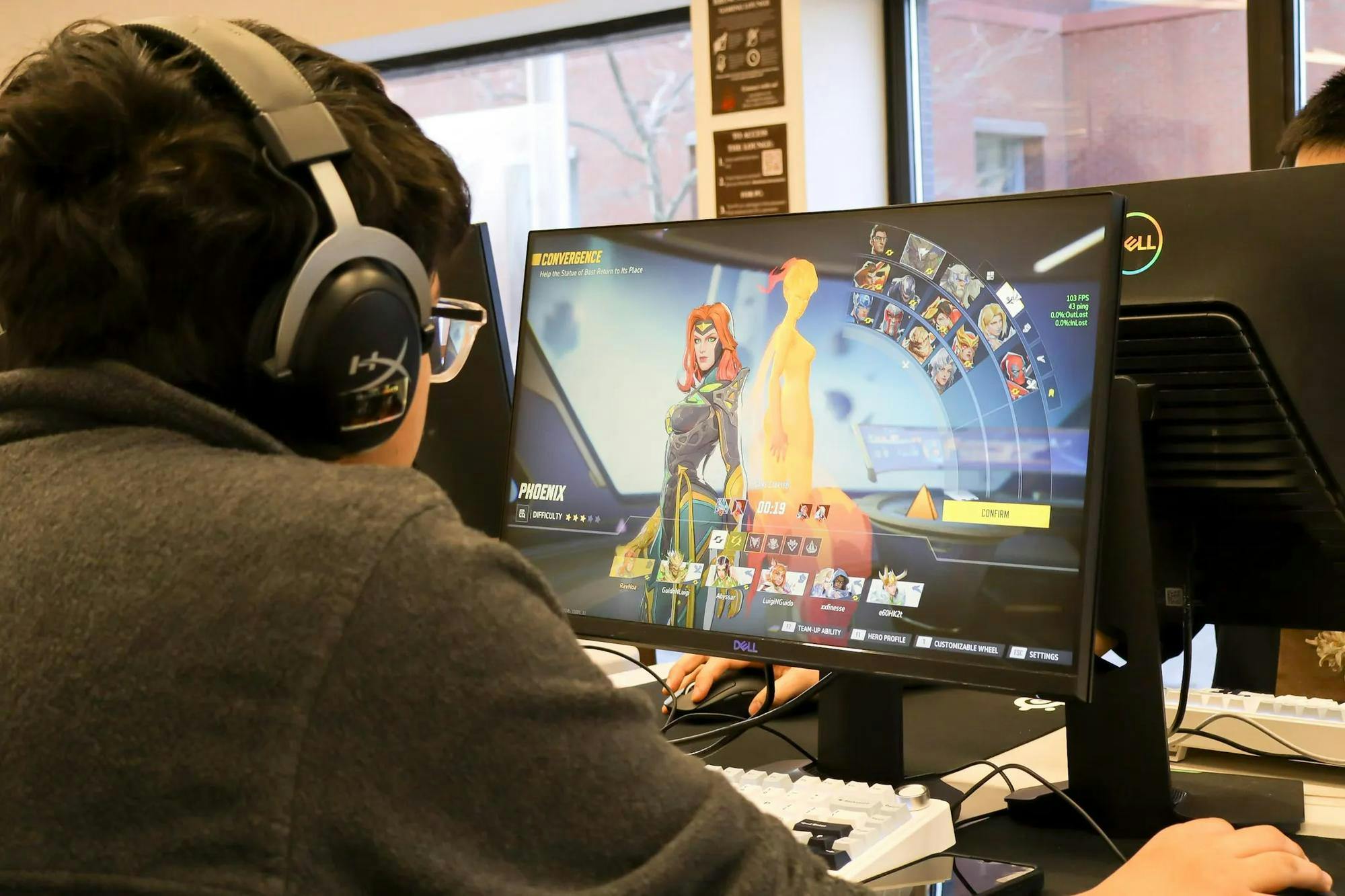 An over-the-shoulder photo of a student playing video games on a desktop.

