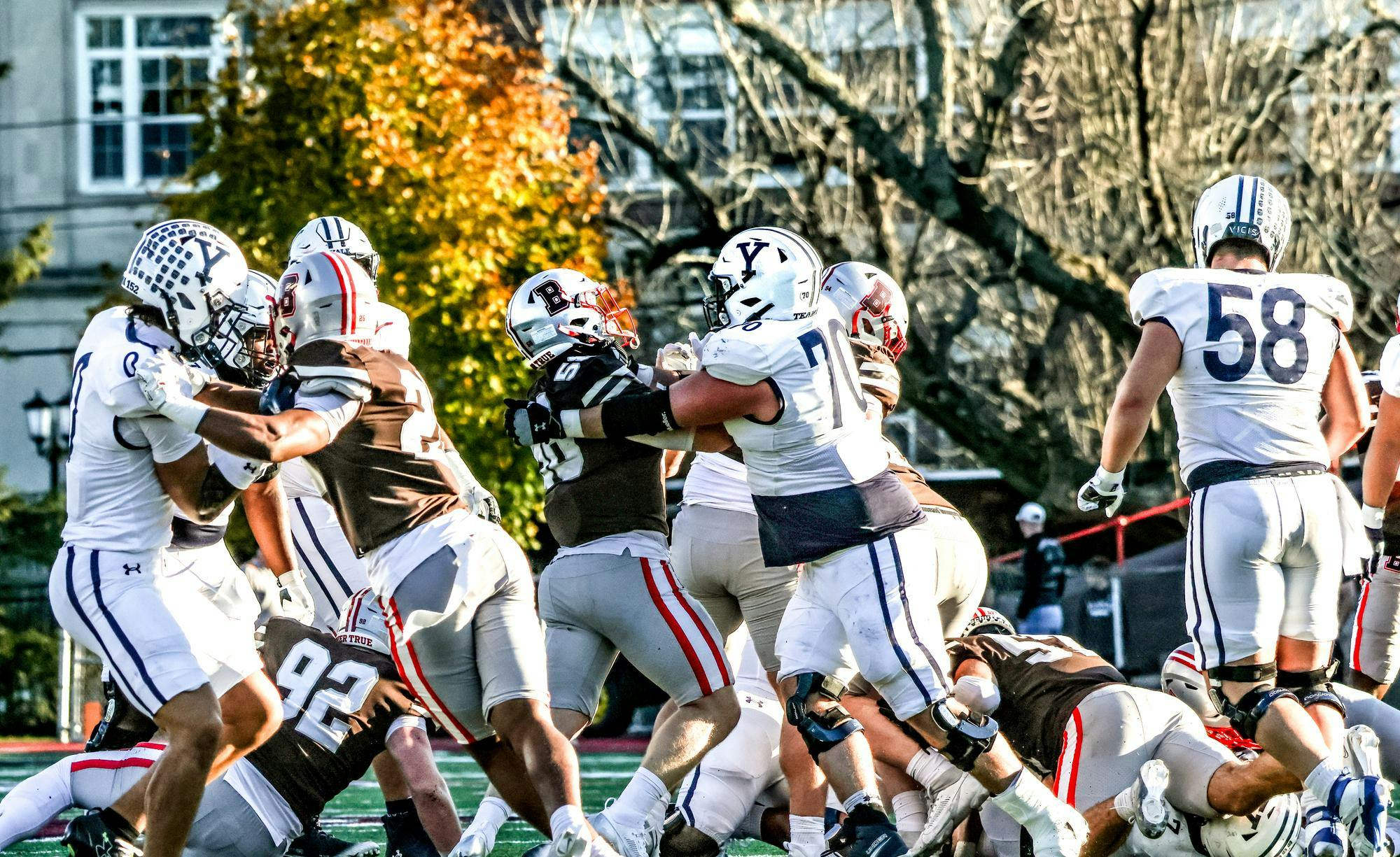 A group of football players is going for a ball. 