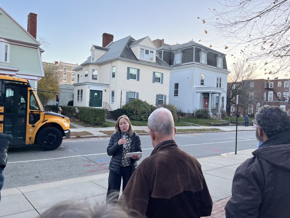 <p>Marisa Brown, executive director of the Providence Preservation Society, speaks to a crowd of around 50 about the histories of 209, 211 and 217 Angell St., which were built in the 19th century. The houses are expected to be demolished early this week.</p>