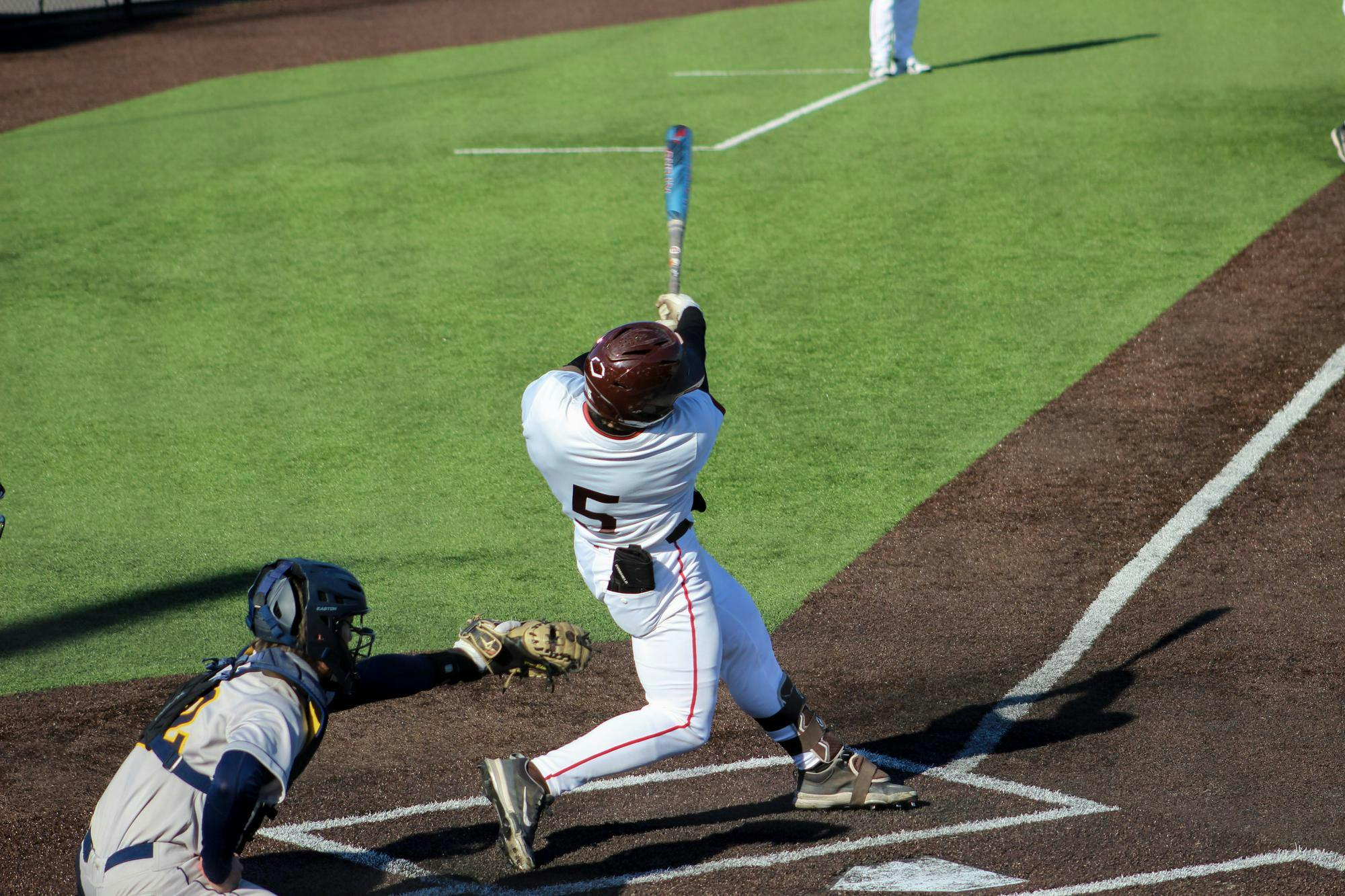 Photo of Alex Benevento ’28 hitting a ball with a blue baseball bat.