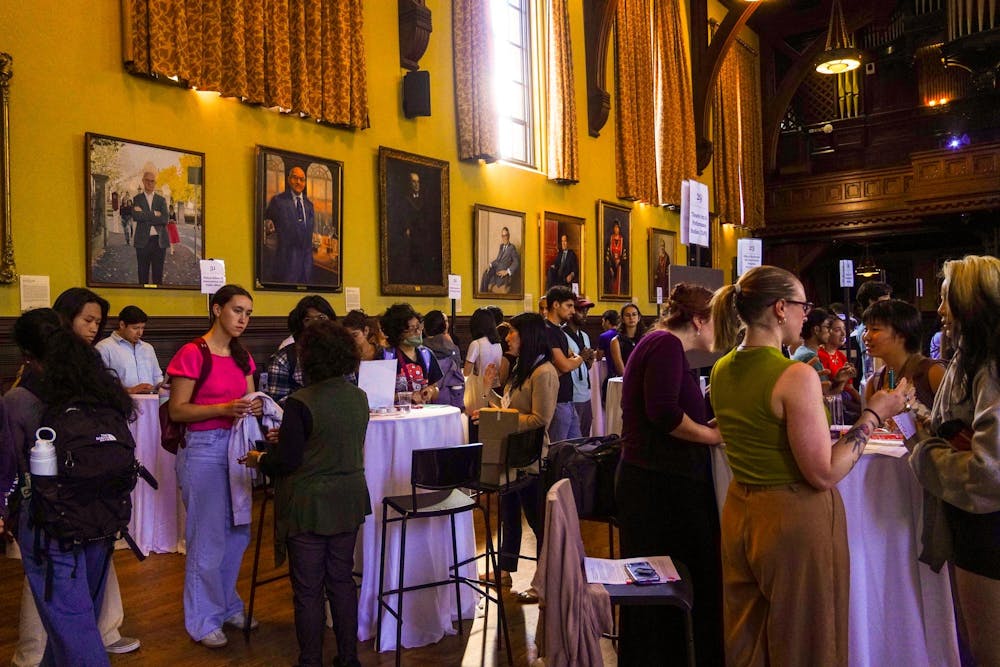 Photo of Friday's job fair in Sayles Hall. Students and recruiters talk at various tables and mill about the room.