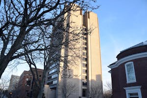 The SciLi is pictured on a sunny day with tree branches in front of it.