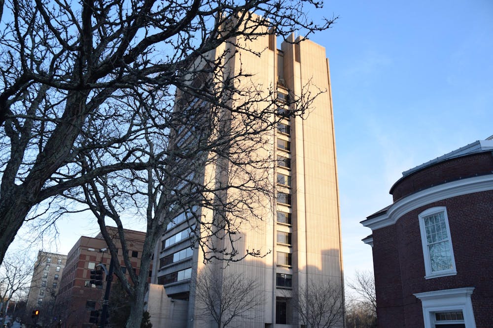 The SciLi is pictured on a sunny day with tree branches in front of it.