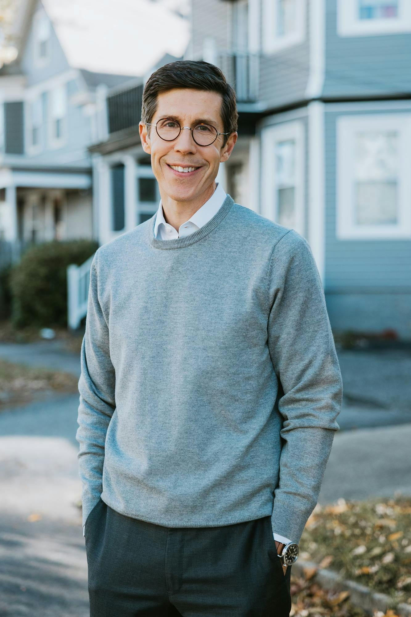 Brett Smiley smiling in a grey sweater.