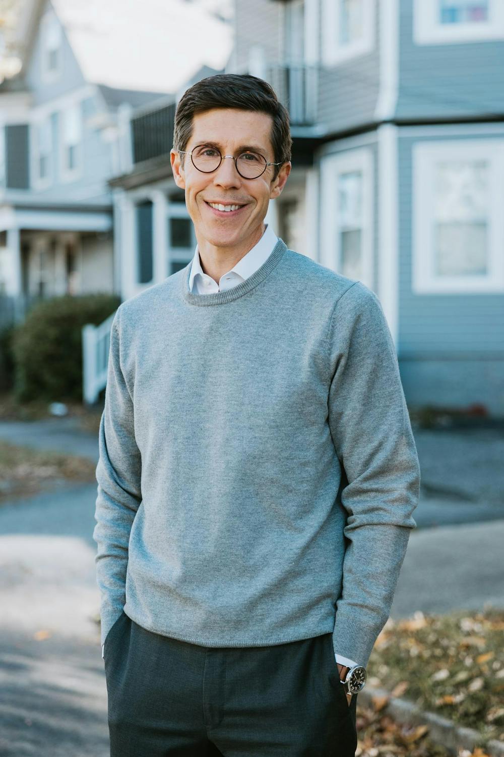 Brett Smiley smiling in a grey sweater.