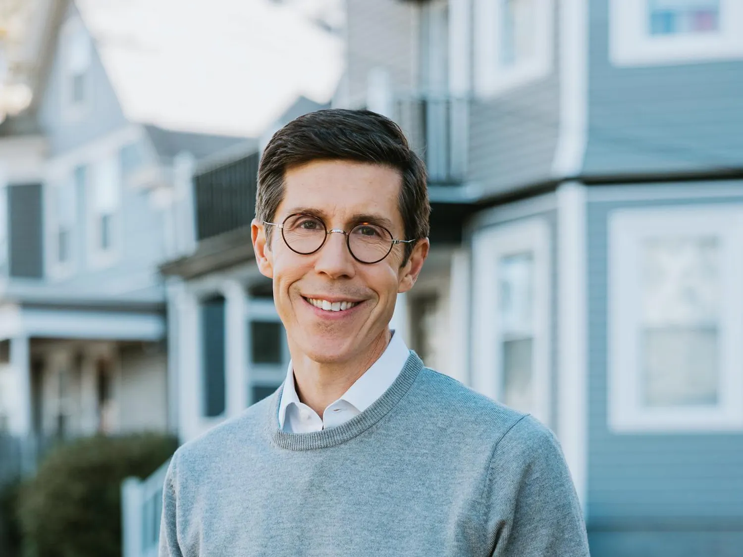Brett Smiley smiling in a grey sweater.