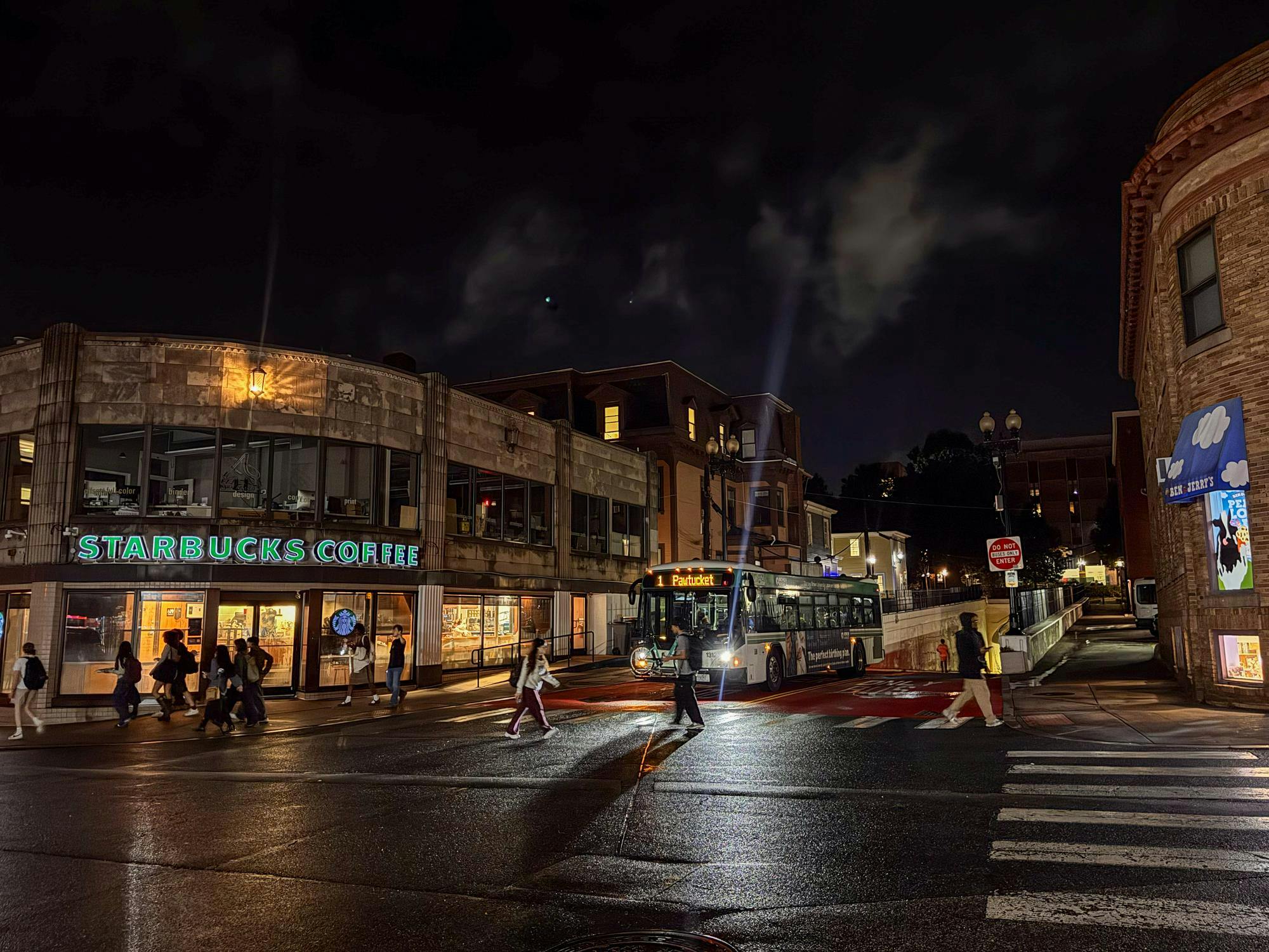 Photo of Thayer Street at night with a bus approaching.