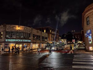Photo of Thayer Street at night with a bus approaching.