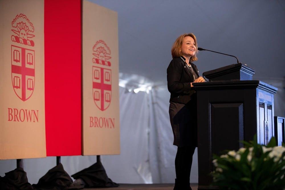 Wendy Schiller stands at a podium in front of a red backdrop.