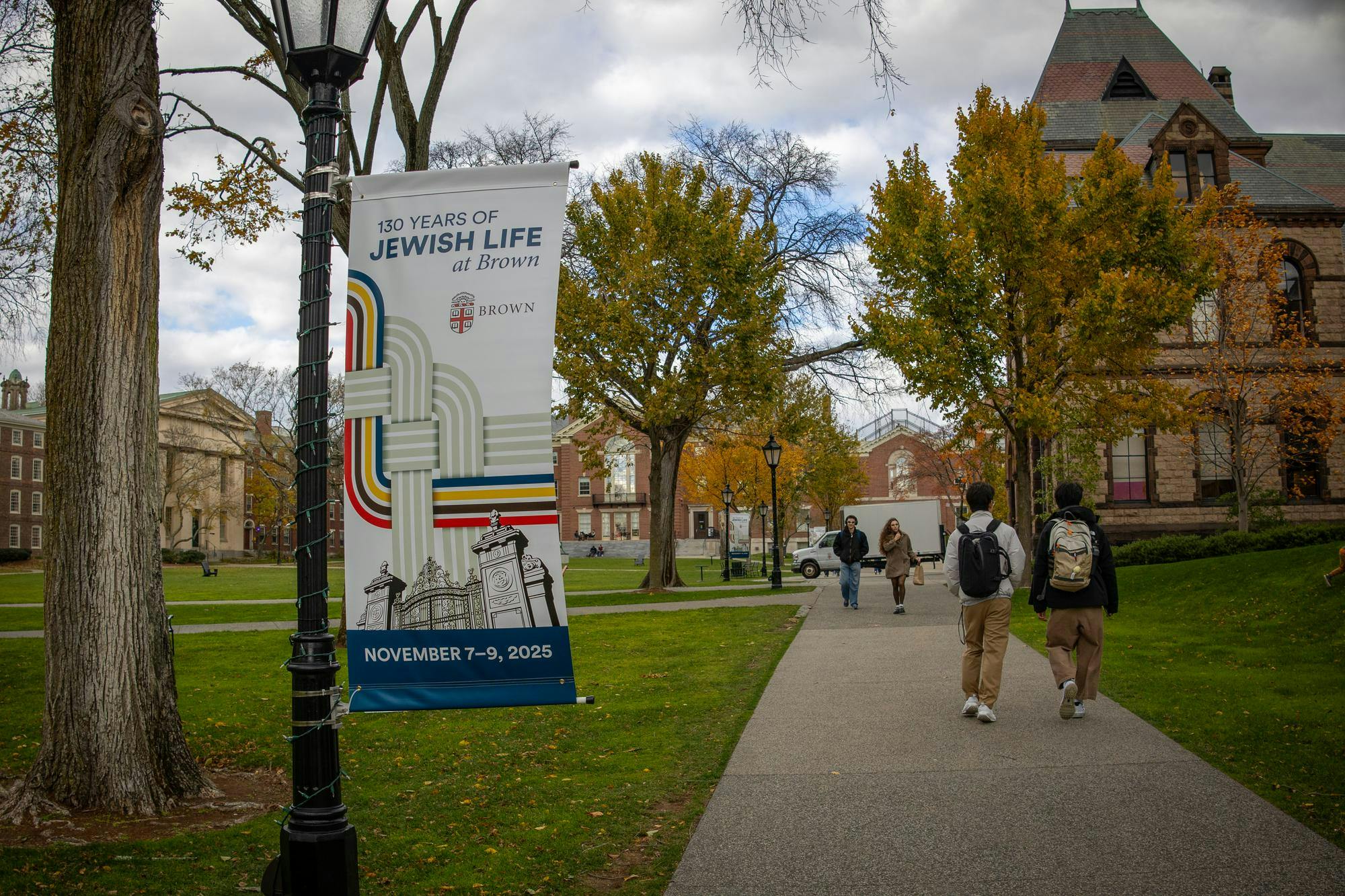 Photo of a banner hanging from a Brown University lamp pole, reading “130 Years of Jewish Life at Brown.” 
