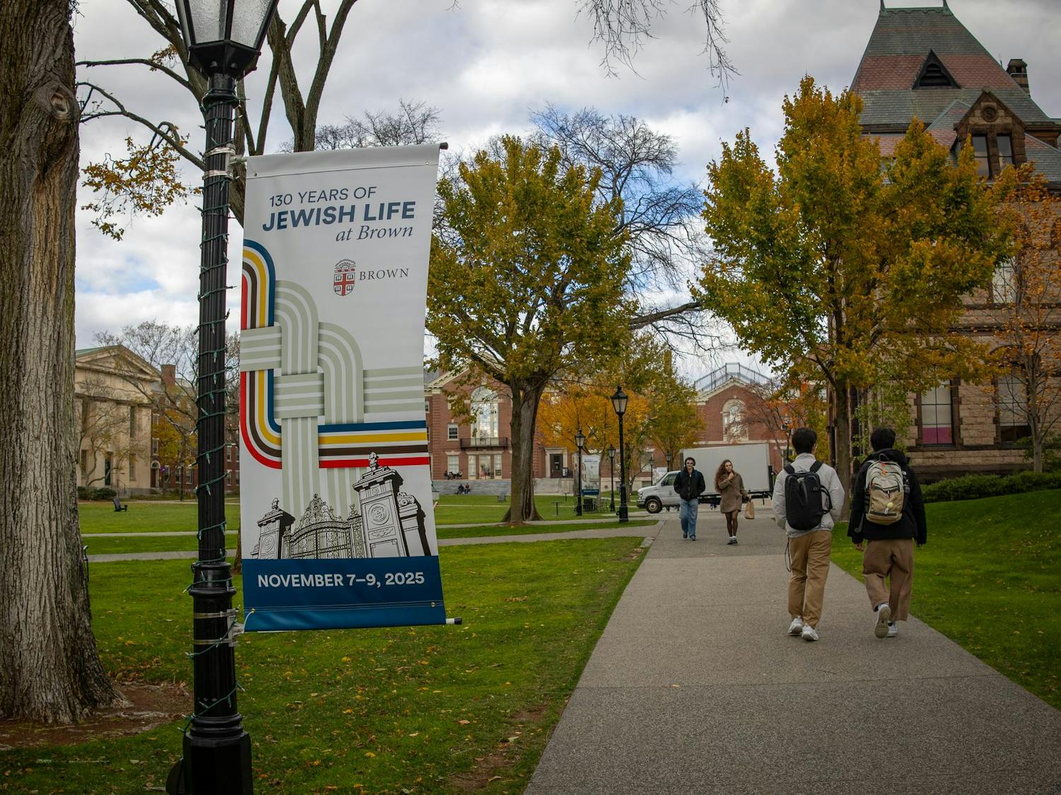 Photo of a banner hanging from a Brown University lamp pole, reading “130 Years of Jewish Life at Brown.”
