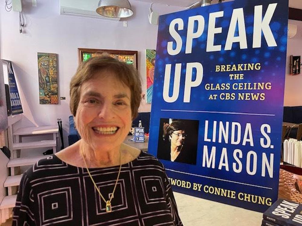 <p><span style="background-color: transparent;">Linda Mason poses in front of a poster for her recent memoir. Mason worked alongside Walter Cronkite, Dan Rather and Charles Kuralt throughout her career and has won 13 Emmy awards.</span></p><p>Courtesy of <span style="background-color: transparent;">Linda Mason</span></p>