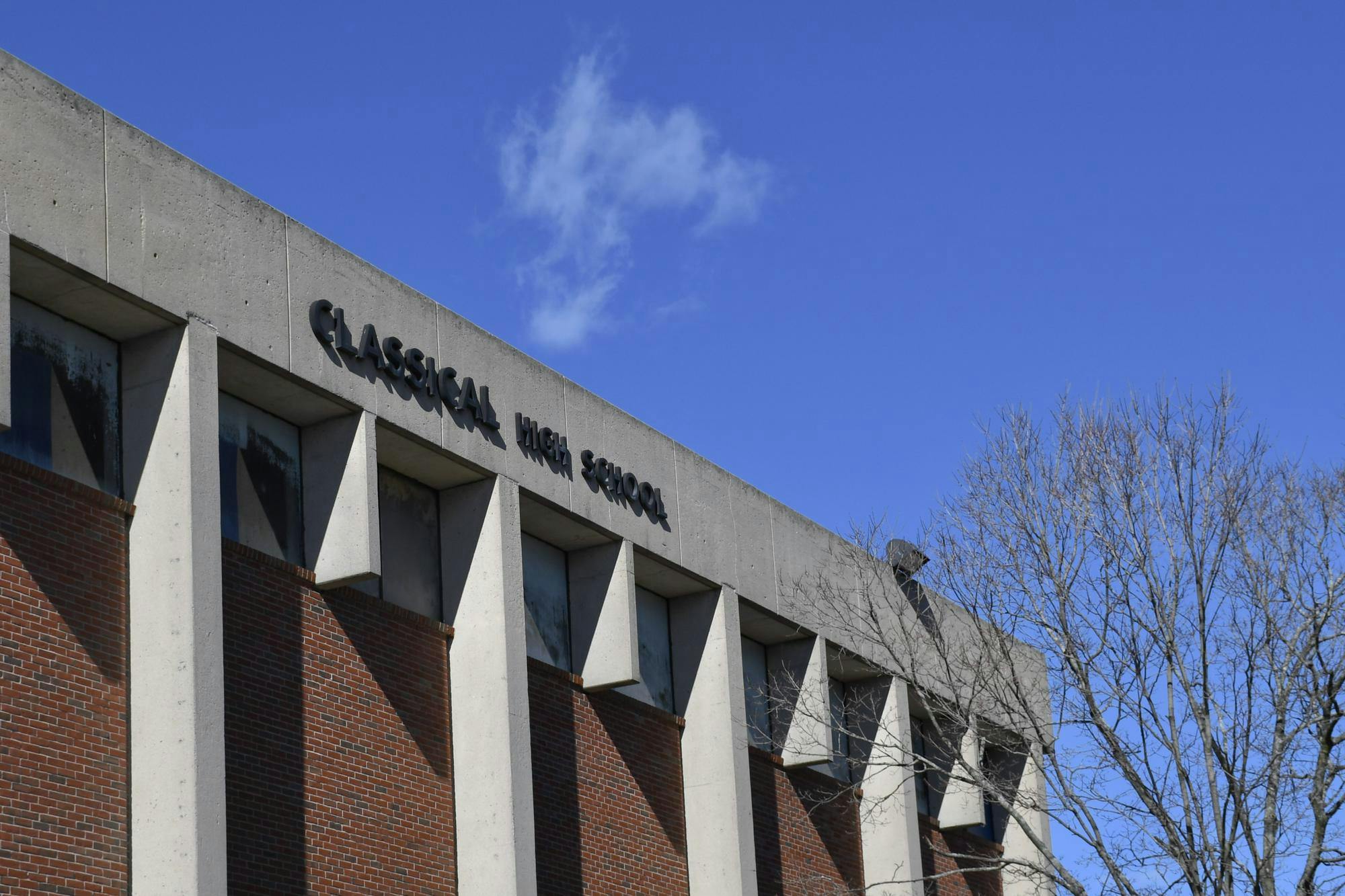 A photo of the outside of Classical High School showing its name labeled on the building on a sunny day. 