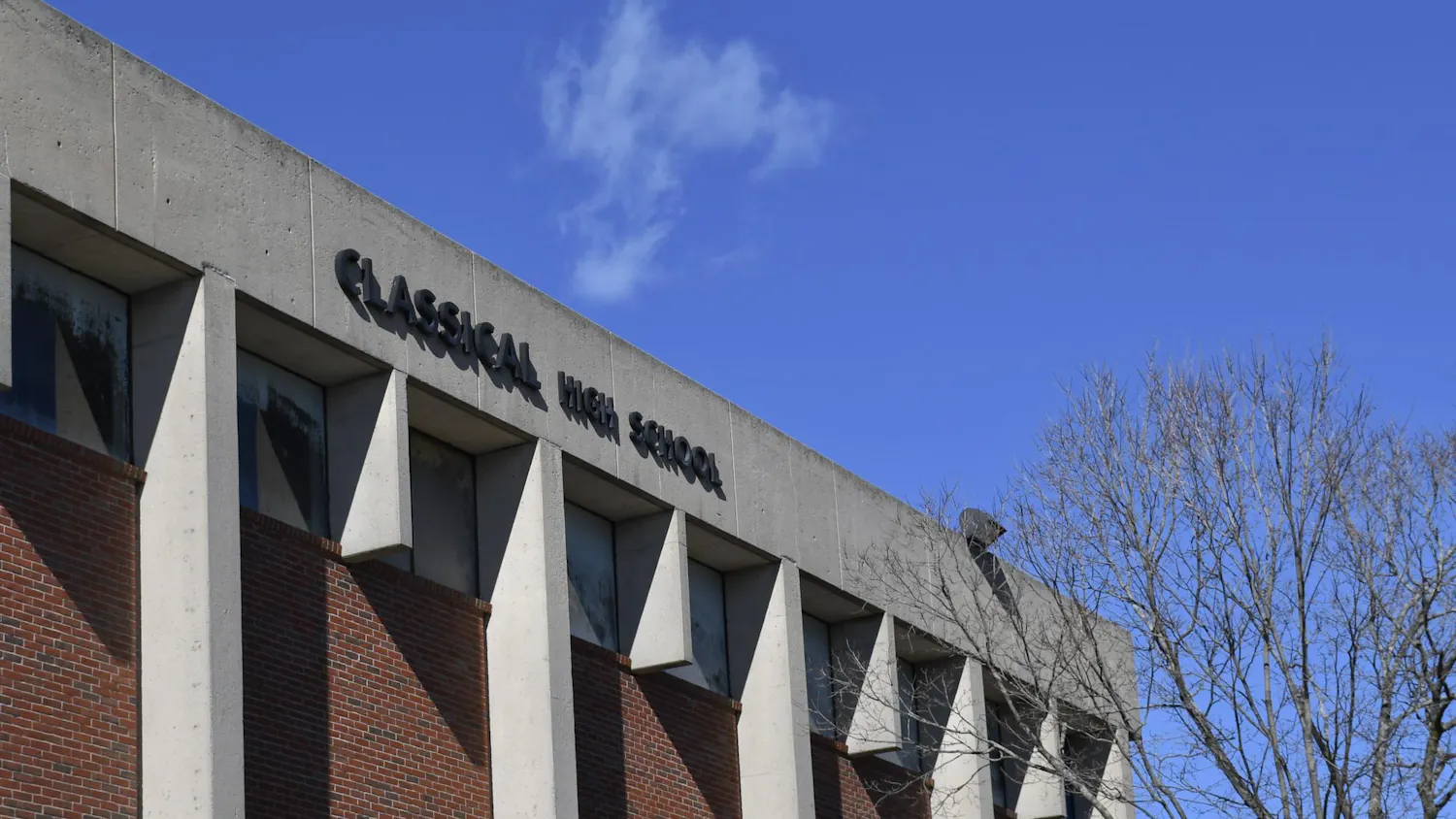 A photo of the outside of Classical High School showing its name labeled on the building on a sunny day.