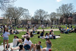 A photograph of the main green with students relaxing on the grass.
