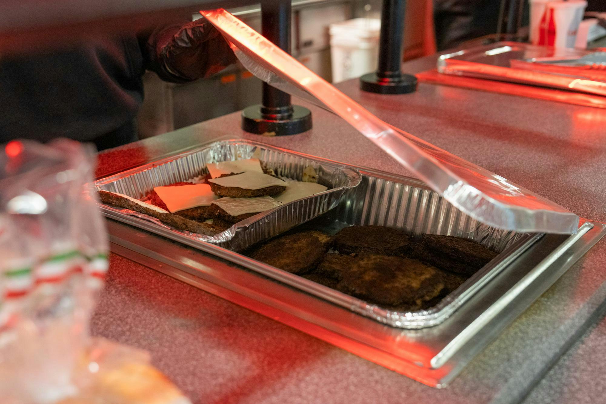 Burger patties in a tinfoil tray.