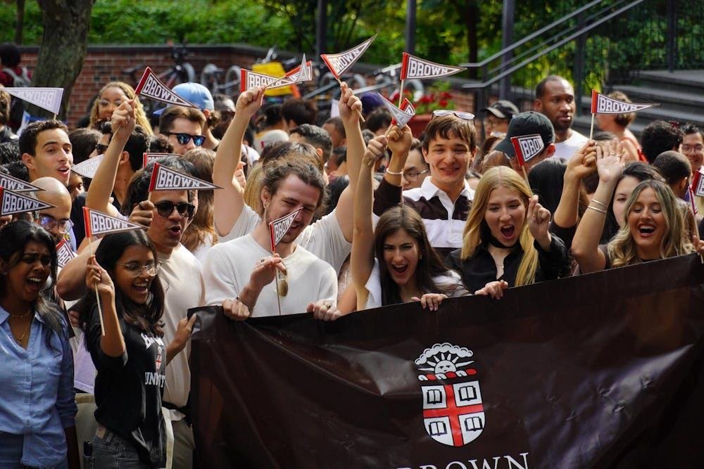 Incoming freshmen are pictured waving Brown flags and holding a Brown banner. 
