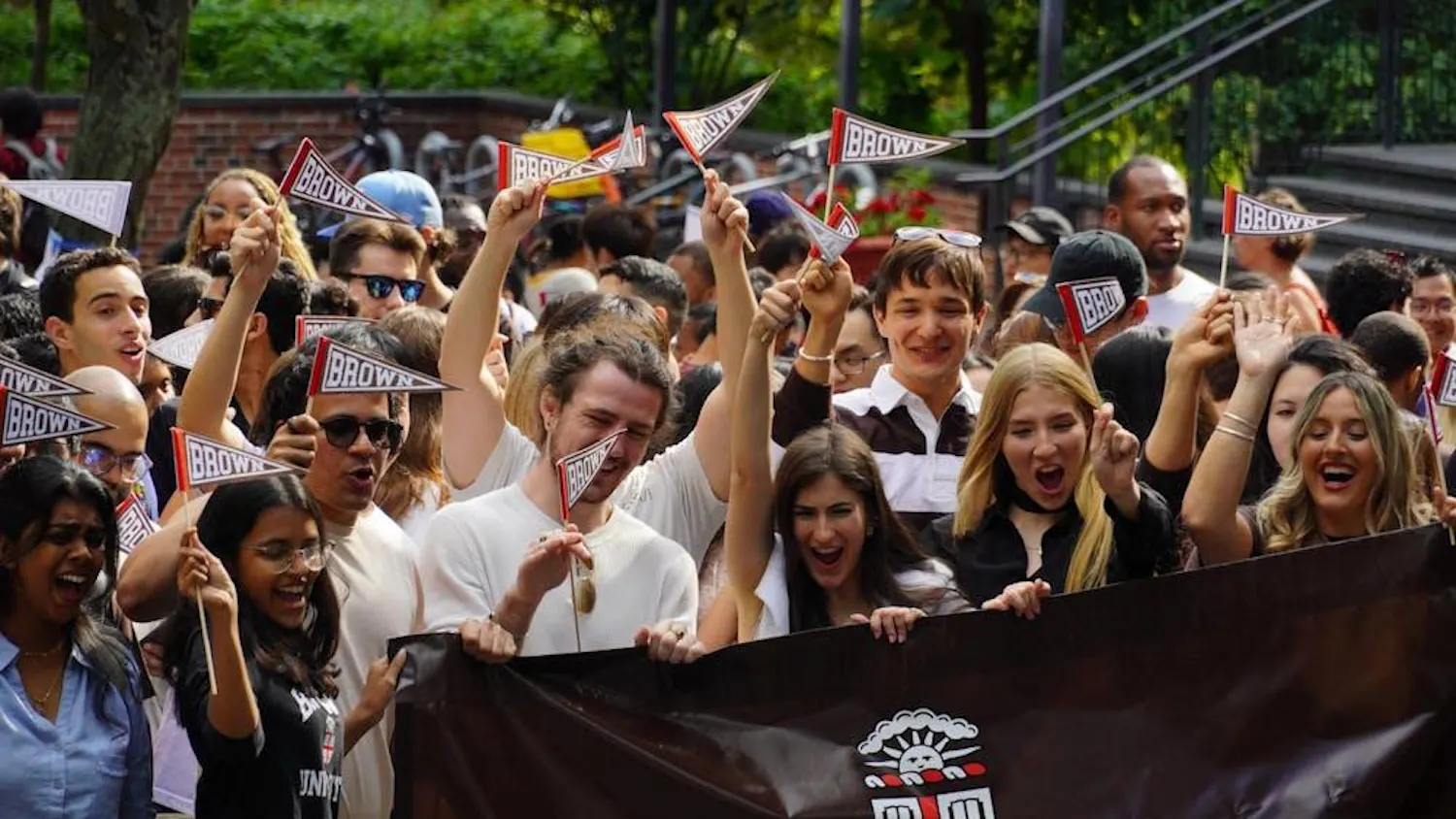 Incoming freshmen are pictured waving Brown flags and holding a Brown banner.
