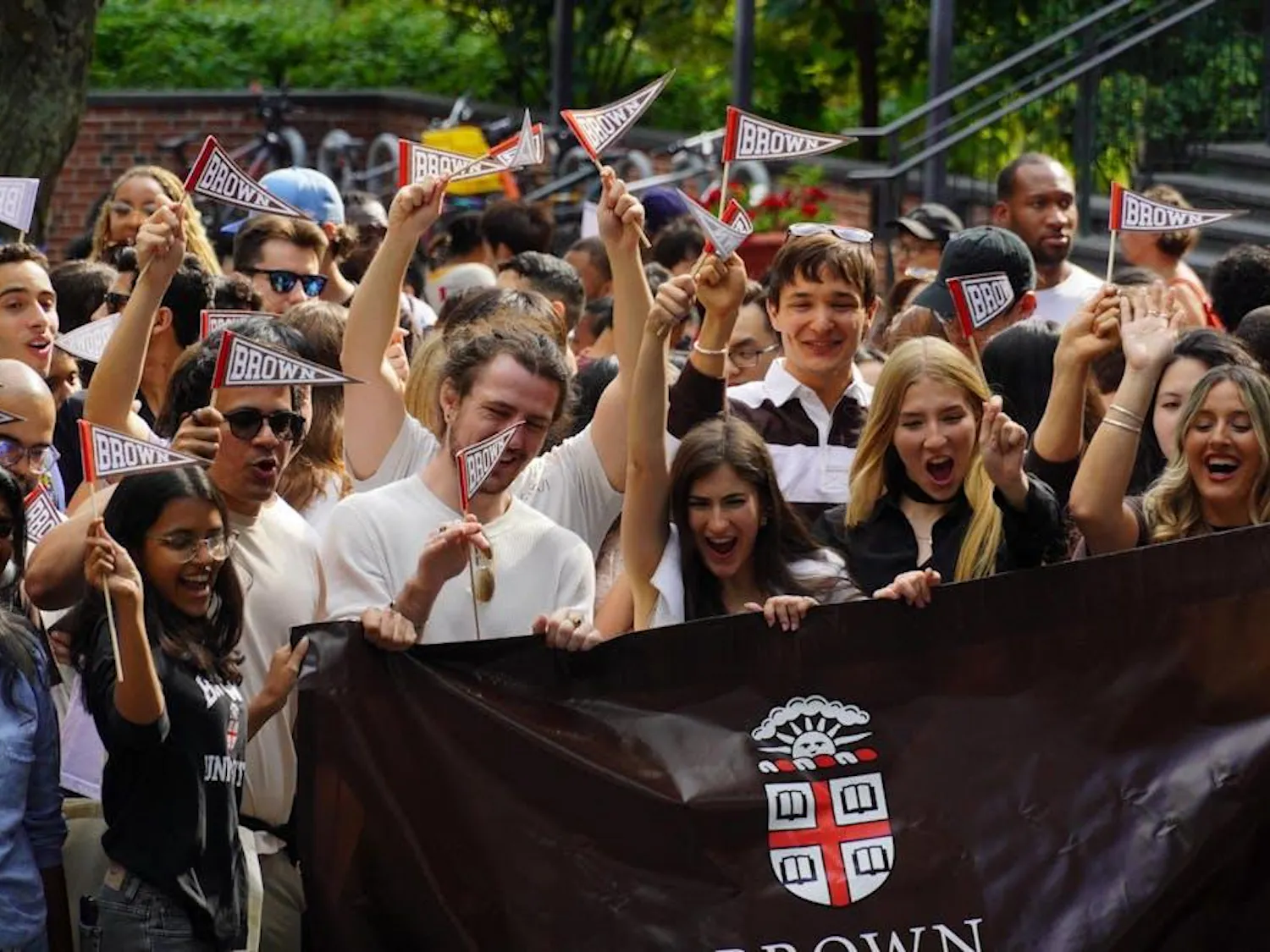Incoming freshmen are pictured waving Brown flags and holding a Brown banner.