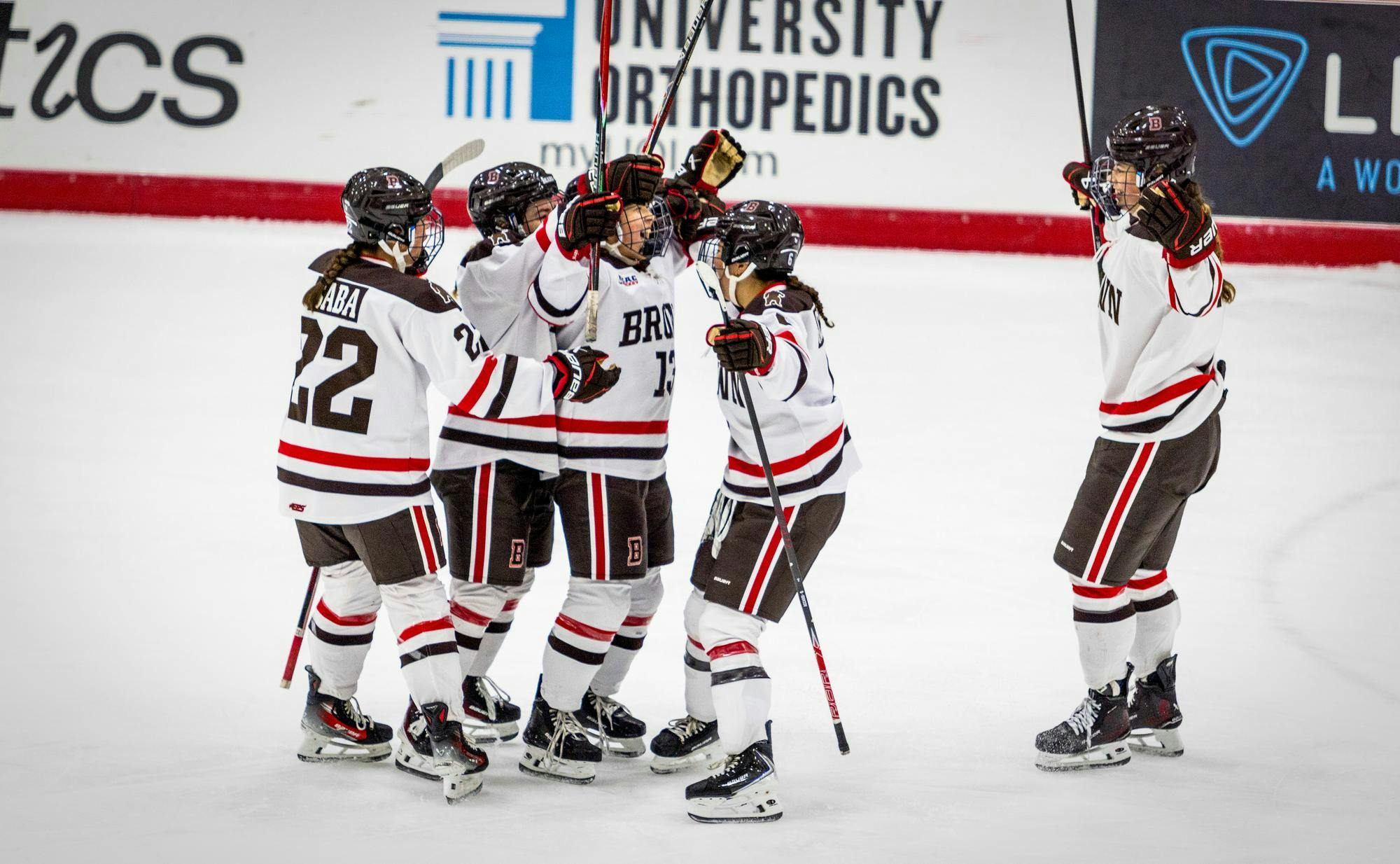 Photo of members of the Brown Hockey Team congregating on the ice rink. 