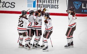 Photo of members of the Brown Hockey Team congregating on the ice rink. 