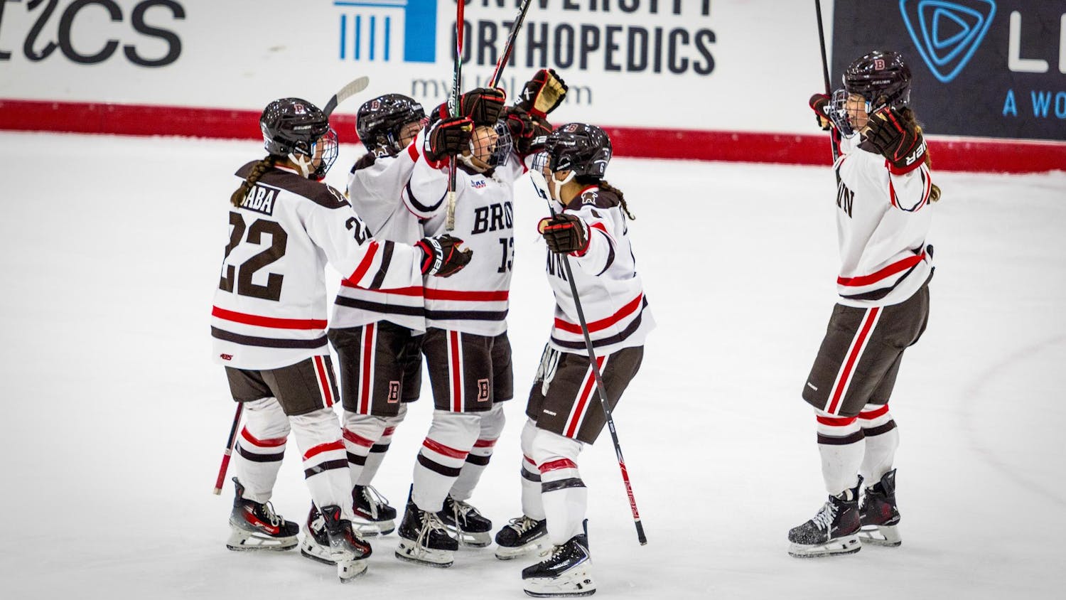 Photo of members of the Brown Hockey Team congregating on the ice rink.