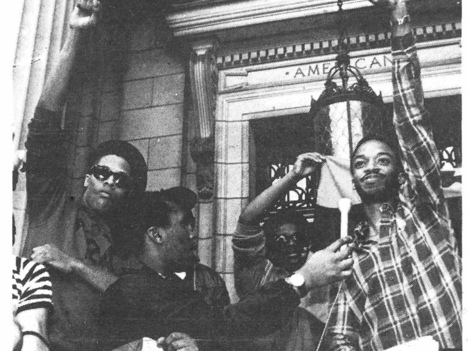 Four men stand outside the John Carter Brown Library, protesting in a black-and-white Herald photo from the 1980s.