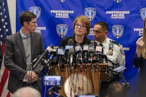 Photo of President Paxson speaking at a podium. To the left is Mayor Brett Smiley. Behind her is Providence Chief of Police Oscar Perez.