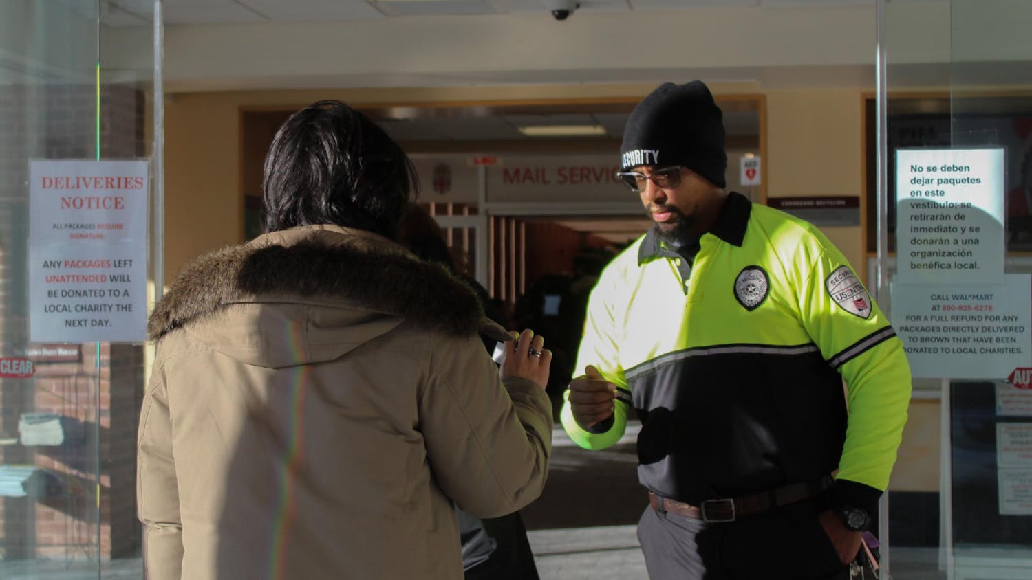 Campus security officer checking a student’s ID at the entrance of Page-Robinson Hall.