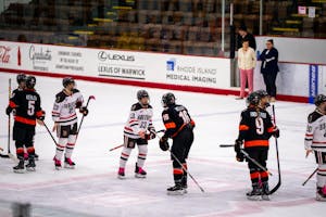 A photo of hockey players exchanging handshakes and high fives on the ice after a match.