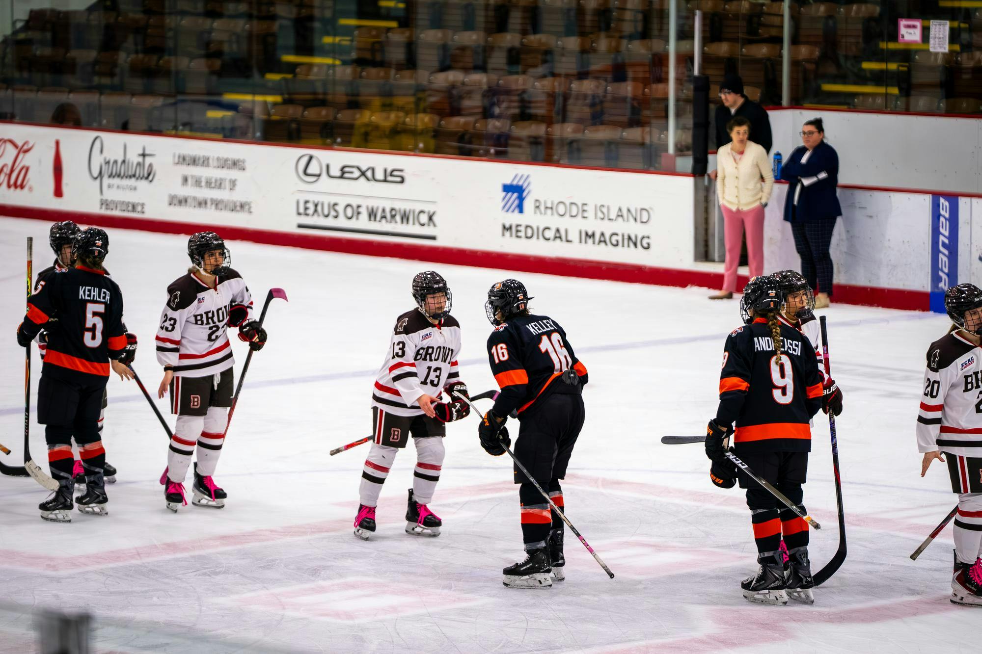 A photo of hockey players exchanging handshakes and high fives on the ice after a match.
