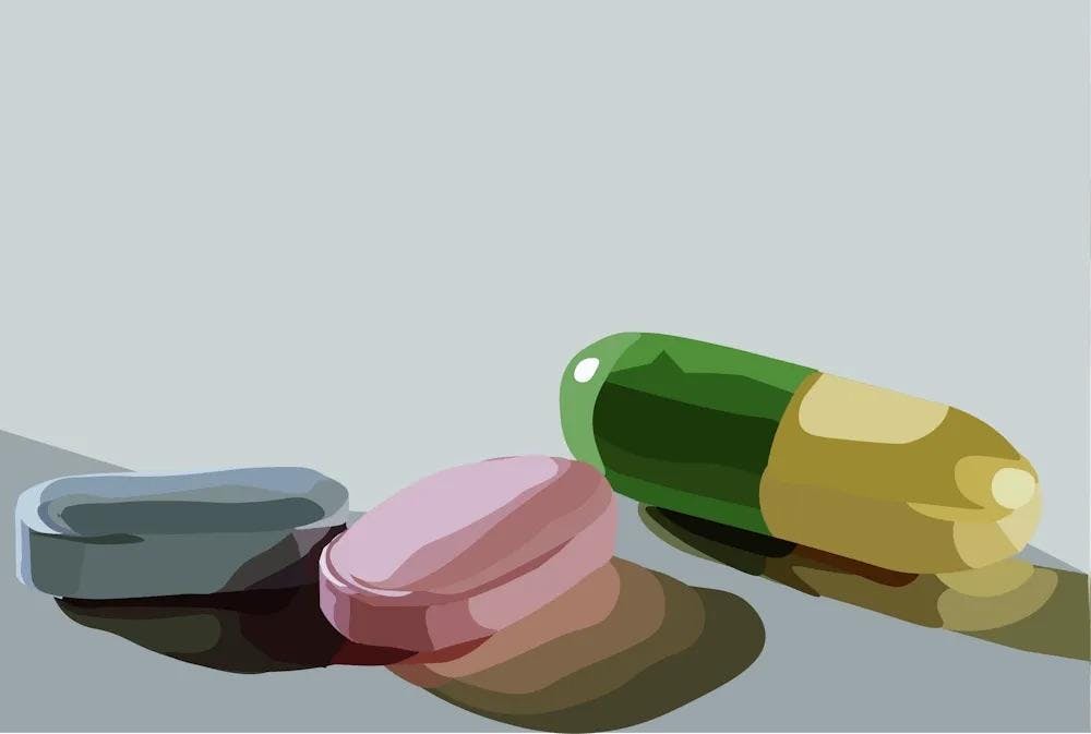 Illustration of a blue pill, a pink pill, and a half-green, half-yellow pill.